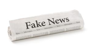 Rolled newspaper with the headline Fake News