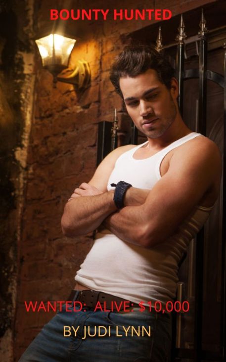 Cover for Bounty Hunted by Judi Lynn shows sexy young man, arms folded, leaning against wall in alley
